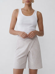Model wearing the grey asymmetric sweat shorts with a relaxed knee-length silhouette