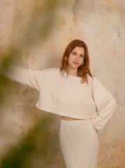 Model wearing the ecru crochet crop top with an oversized textured silhouette by Cossac