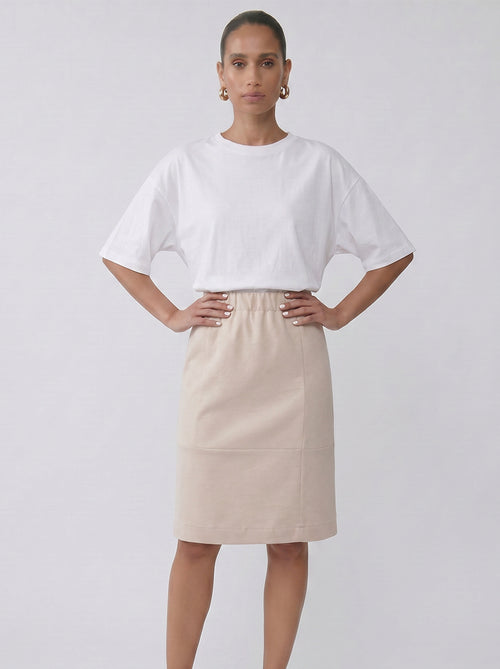 Woman wearing the Lauren Skirt in light sand styled as a soft minimal outfit by noumenon