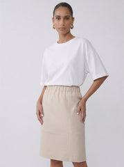 Model wearing the light sand Lauren Skirt with a relaxed pencil silhouette by Noumenon