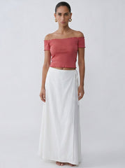 Model wearing the coral Penelope Top with a slightly cropped feminine silhouette