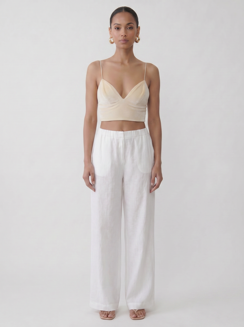 Model wearing the vegan cream upcycled bralette with a fitted silhouette and vintage fabric look on a plain background by Noumenon