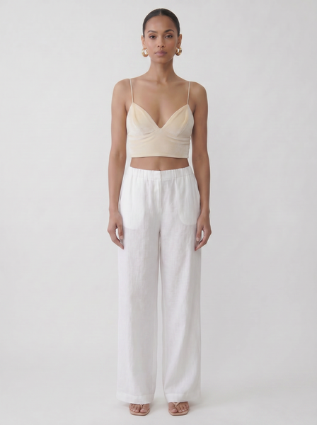 Model wearing the vegan cream upcycled bralette with a fitted silhouette and vintage fabric look on a plain background by Noumenon