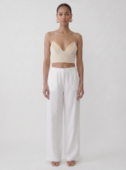 Model wearing the vegan cream upcycled bralette with a fitted silhouette and vintage fabric look on a plain background by Noumenon